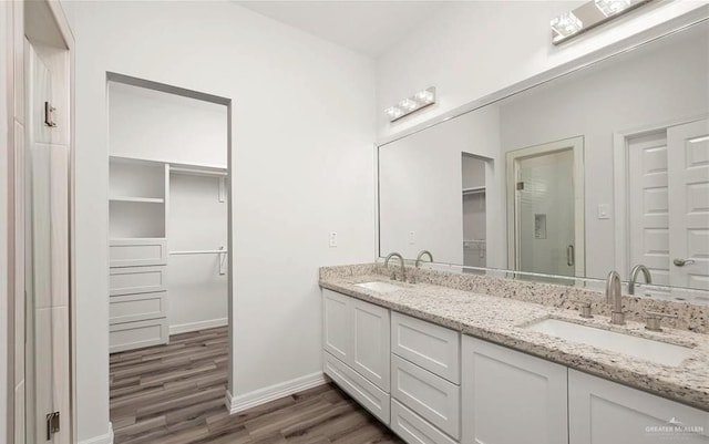 bathroom with hardwood / wood-style floors, vanity, and a shower with door