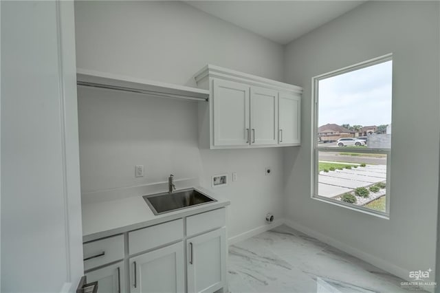 clothes washing area with cabinet space, a sink, hookup for a washing machine, baseboards, and hookup for an electric dryer