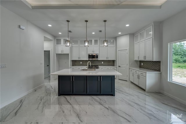 kitchen with white cabinets, stainless steel microwave, and baseboards
