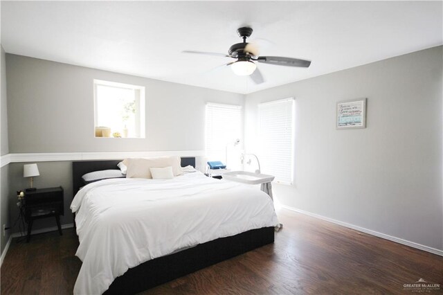 bedroom featuring dark wood-style flooring, a ceiling fan, and baseboards