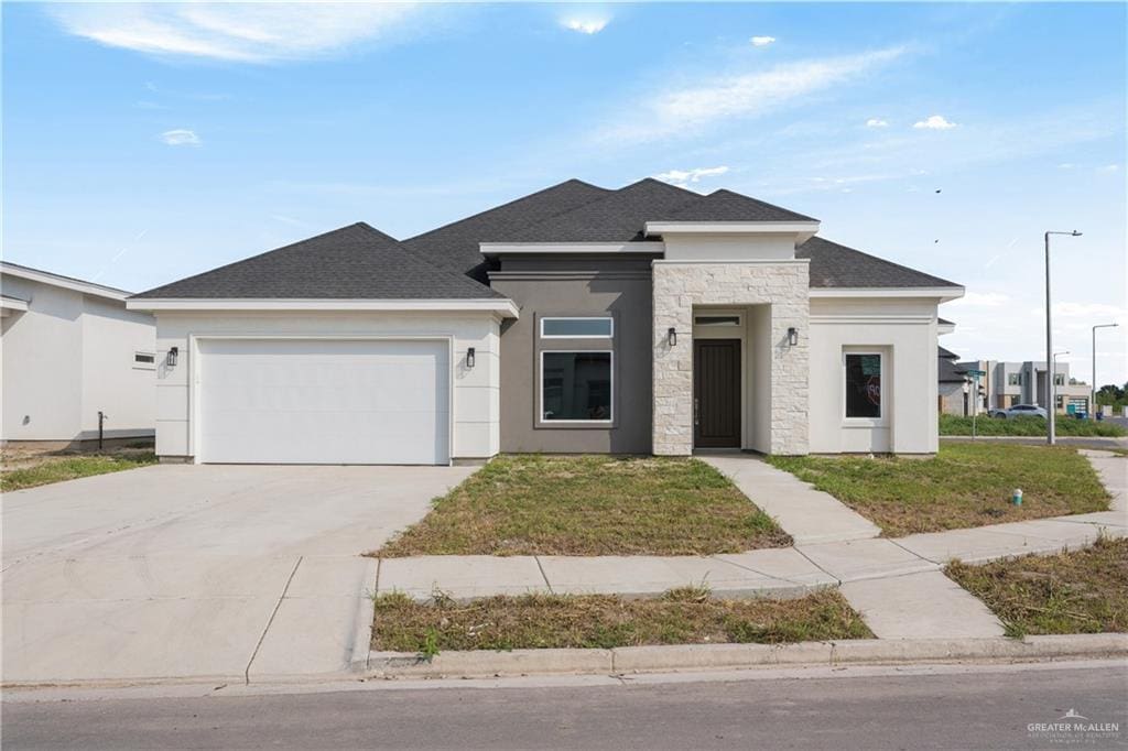 8827 Wentz Lk, Brownsville, TX 78520 - view of front of house featuring driveway, stucco siding, roof with shingles, and an attached garage