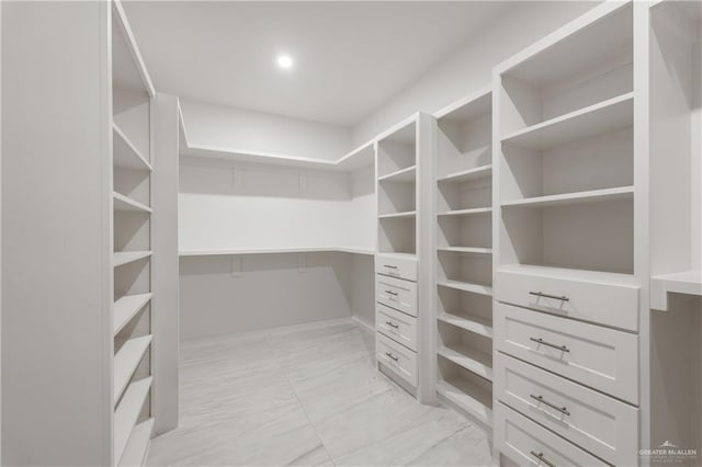 walk in closet featuring marble finish floor