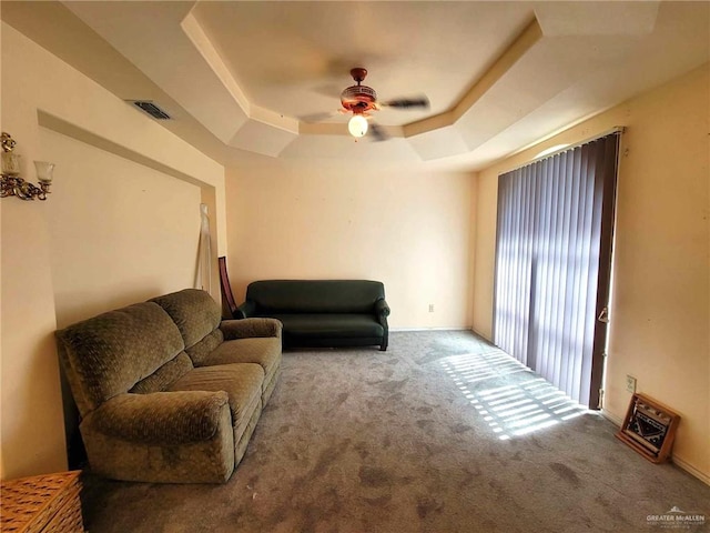 living area featuring a tray ceiling, ceiling fan, and light colored carpet