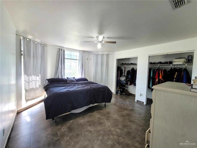 bedroom featuring ceiling fan and multiple closets