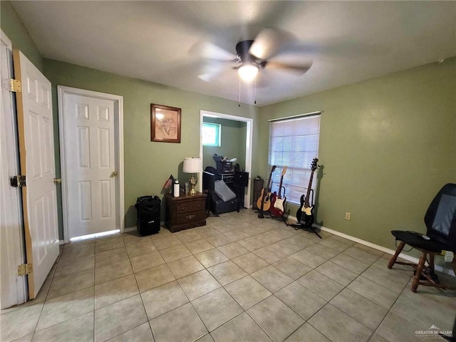 interior space with light tile patterned floors and ceiling fan