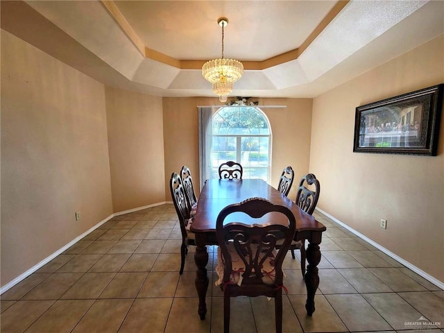 dining room featuring a raised ceiling, an inviting chandelier, and dark tile patterned flooring