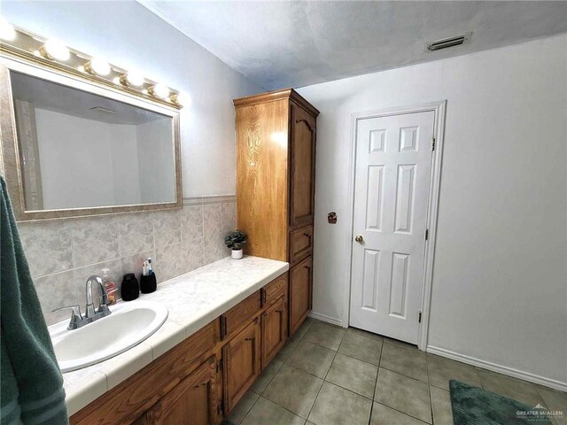 bathroom with backsplash, tile patterned floors, and vanity