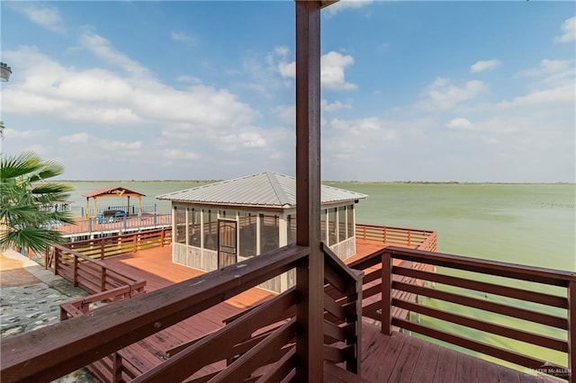 wooden deck with a water view and a sunroom