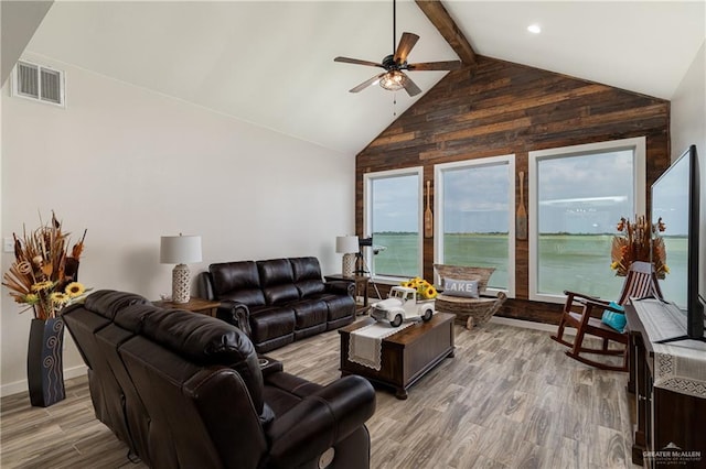 living room featuring light wood-type flooring, lofted ceiling with beams, and ceiling fan