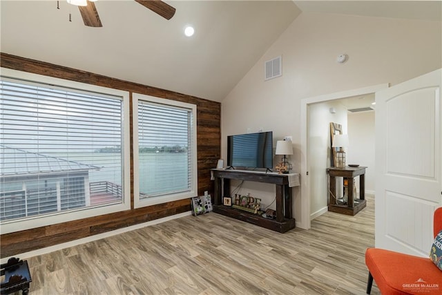 living room with vaulted ceiling, light hardwood / wood-style flooring, and ceiling fan