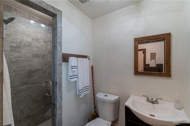 bathroom featuring vanity, toilet, and a shower with shower door