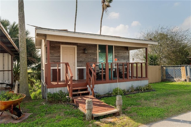 rear view of property with a porch and a yard