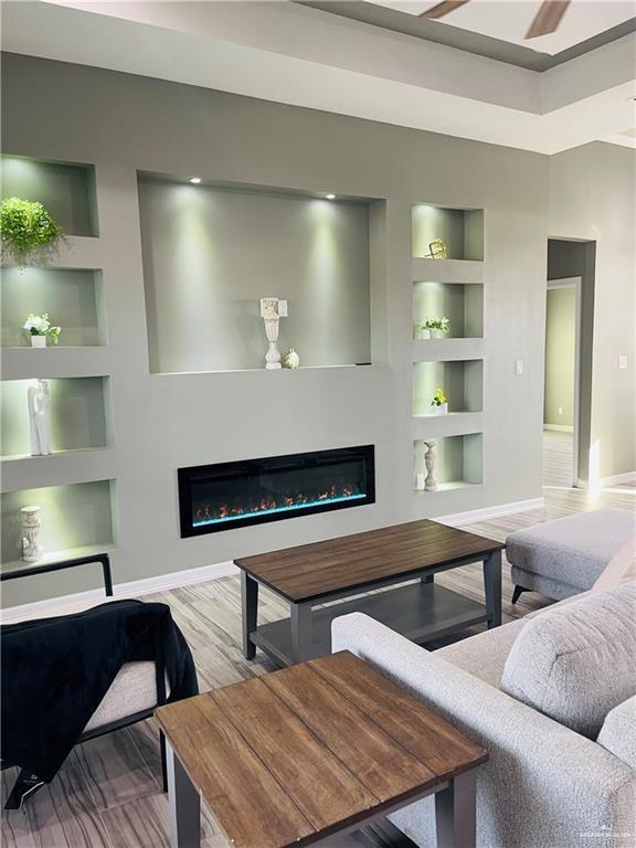 living room featuring built in features and wood-type flooring