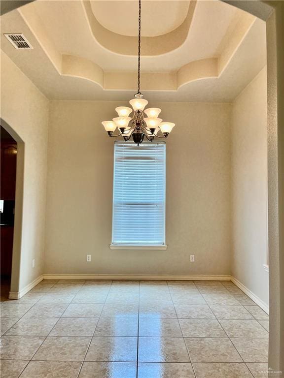 unfurnished room with a chandelier, a raised ceiling, arched walkways, and visible vents