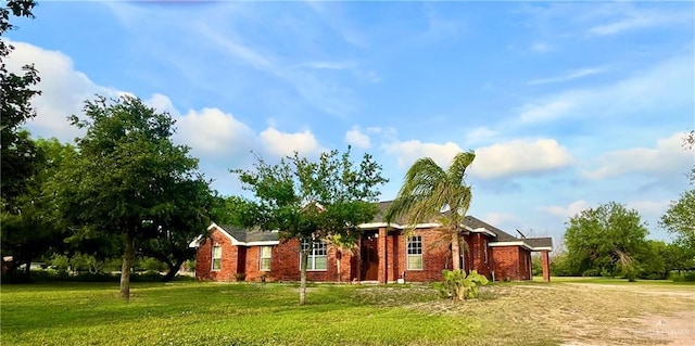 single story home featuring a front yard and brick siding