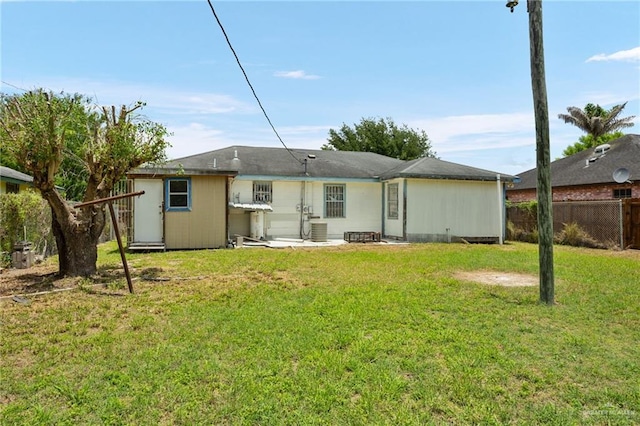 back of house with central AC and a lawn