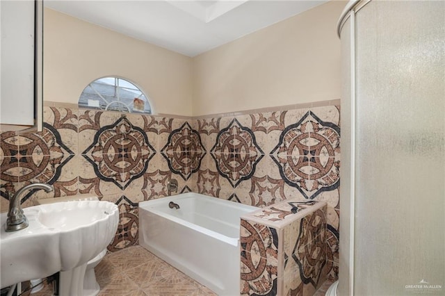 bathroom with sink and a tub to relax in