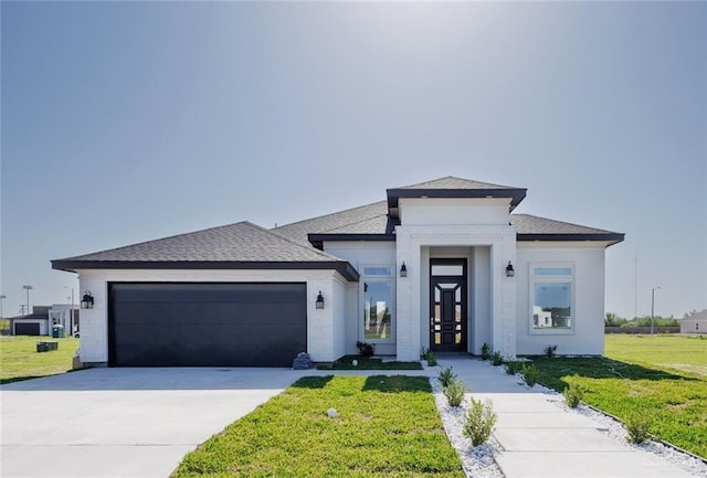 303 N 31st St, Hidalgo, TX 78557 - prairie-style home featuring an attached garage, a front yard, concrete driveway, french doors, and roof with shingles
