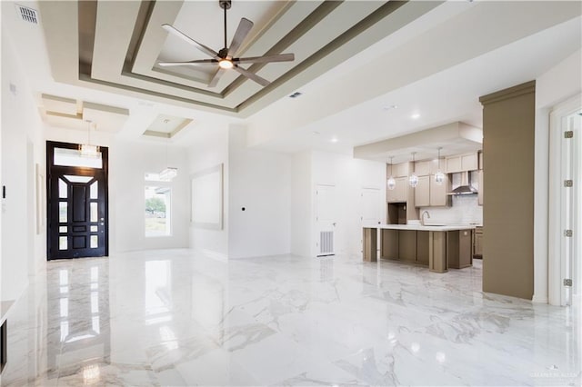 303 N 31st St, Hidalgo, TX 78557 - unfurnished living room featuring ceiling fan, a raised ceiling, and light marble finish floors