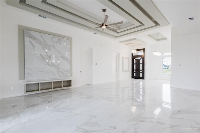 303 N 31st St, Hidalgo, TX 78557 - empty room featuring marble tiled floors, a ceiling fan, and a tray ceiling