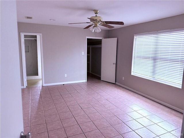 tiled empty room featuring ceiling fan