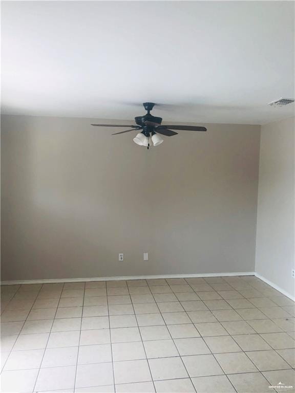 tiled spare room featuring ceiling fan