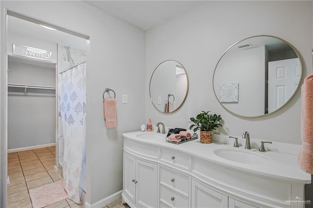 bathroom featuring tile patterned floors, double vanity, and baseboards