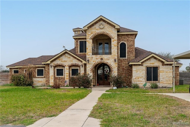 view of front of property with french doors, a front lawn, a shingled roof, and a balcony