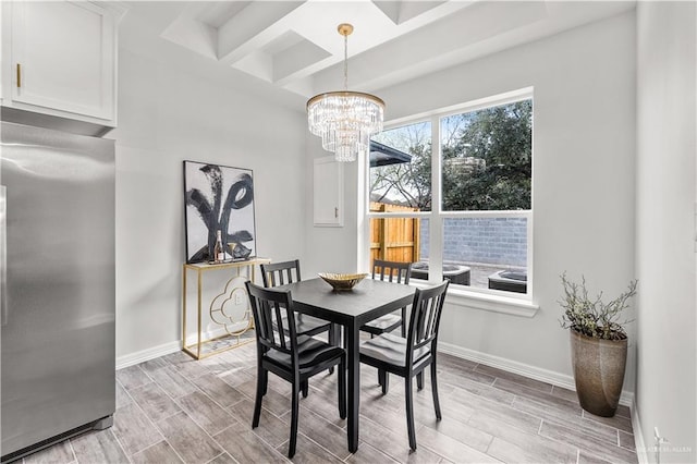 dining area with a chandelier, wood finish floors, and baseboards