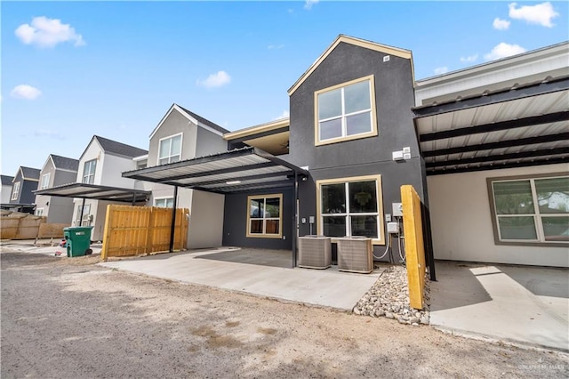 view of front of house featuring a patio area, fence, central AC, and stucco siding