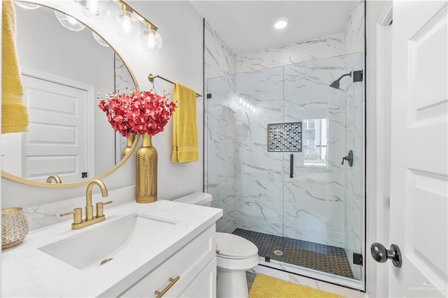 bathroom featuring toilet, vanity, and a marble finish shower