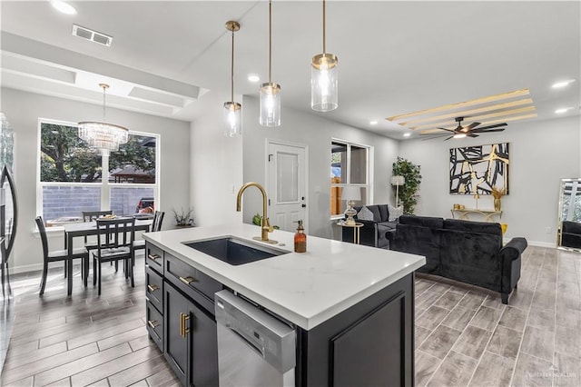 kitchen with dishwasher, wood finish floors, a sink, and visible vents