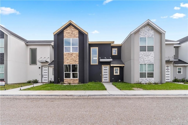 view of front of home featuring stone siding and stucco siding