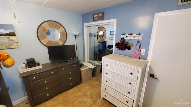 bedroom with a closet and light tile patterned flooring