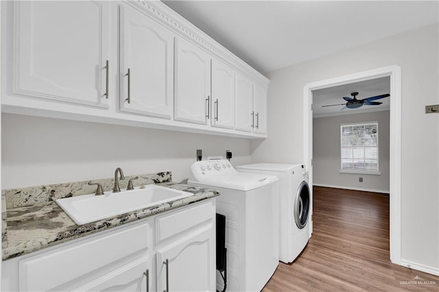 clothes washing area with sink, cabinets, separate washer and dryer, light wood-type flooring, and ceiling fan