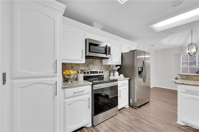 kitchen with light hardwood / wood-style flooring, stainless steel appliances, light stone counters, white cabinets, and decorative backsplash