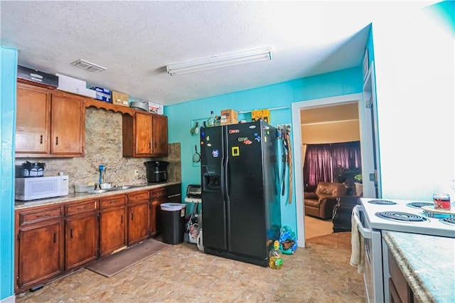 kitchen with light countertops, visible vents, brown cabinetry, and white appliances