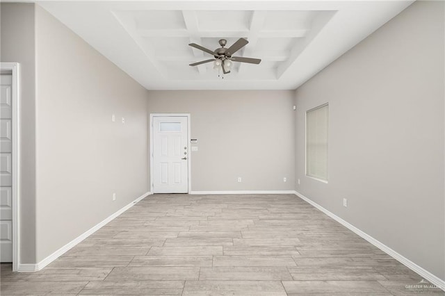 unfurnished room with coffered ceiling, a ceiling fan, light wood-type flooring, and baseboards