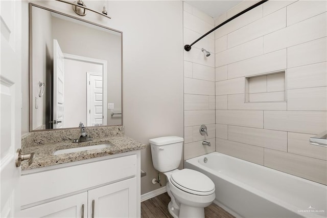 full bathroom with toilet, wood finished floors, baseboards, bathtub / shower combination, and vanity