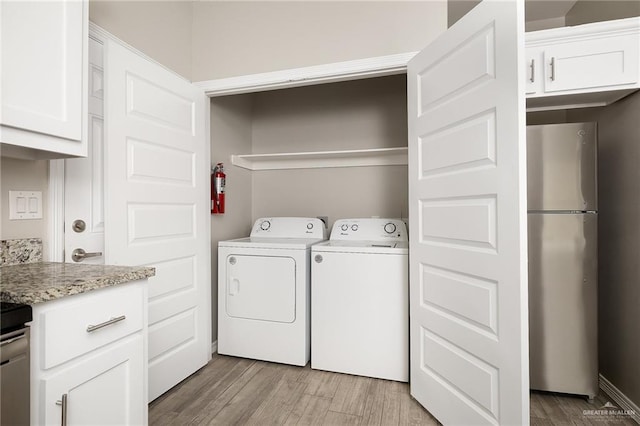 laundry room featuring washing machine and clothes dryer, laundry area, and light wood-style flooring