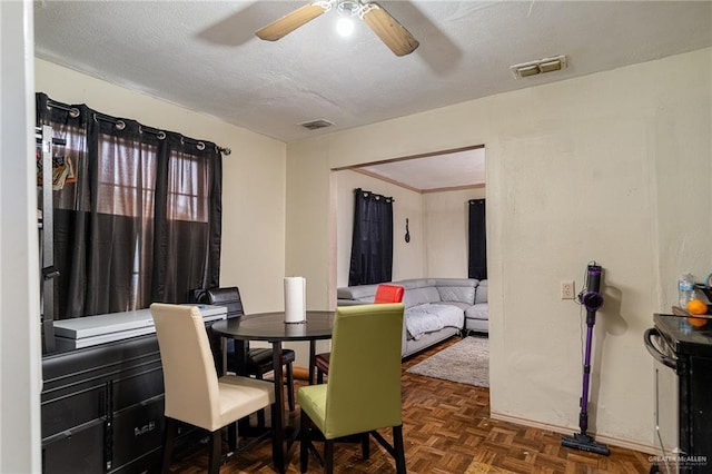 dining room featuring ceiling fan, visible vents, and a textured ceiling