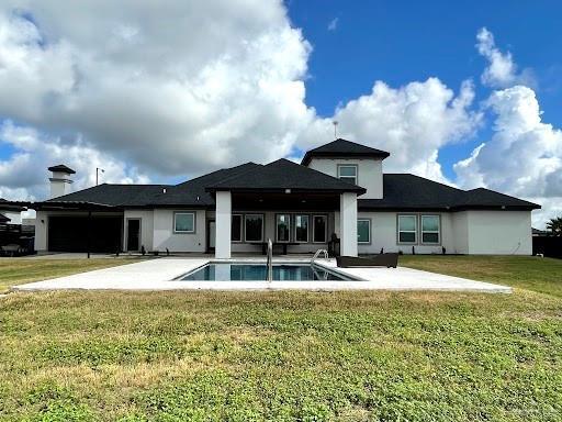 back of house featuring a patio area, an outdoor pool, and a yard