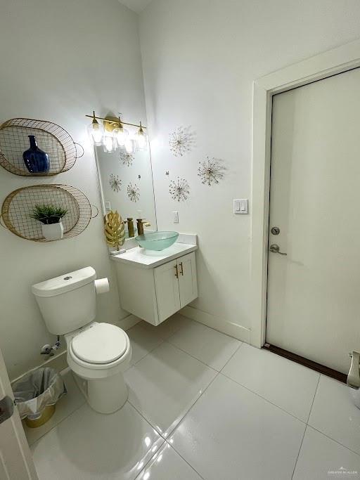 bathroom featuring tile patterned flooring, baseboards, vanity, and toilet