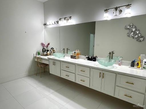 bathroom with tile patterned flooring, a sink, and double vanity