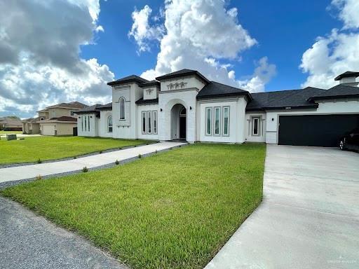 view of front of home featuring a garage, driveway, and a front lawn