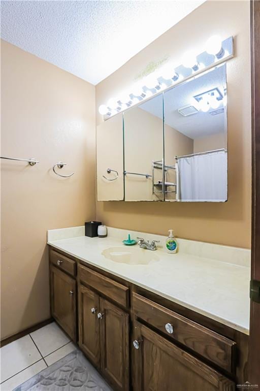 bathroom featuring tile patterned floors, vanity, and a textured ceiling