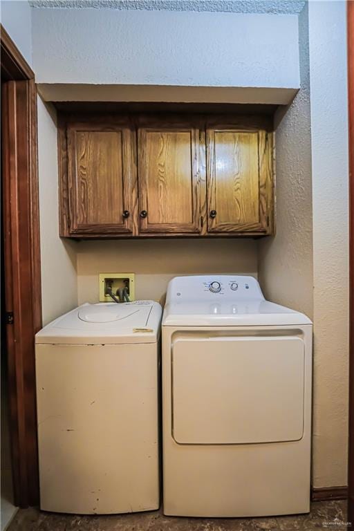 laundry room with washer and dryer and cabinets