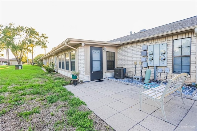 back of house with a lawn, cooling unit, and a patio