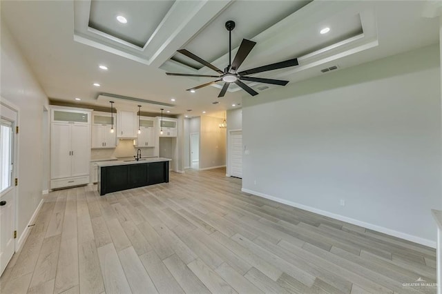 1310 S 9th St, Alamo, TX 78516 - kitchen featuring open floor plan, a center island with sink, light wood-style flooring, a ceiling fan, and white cabinets
