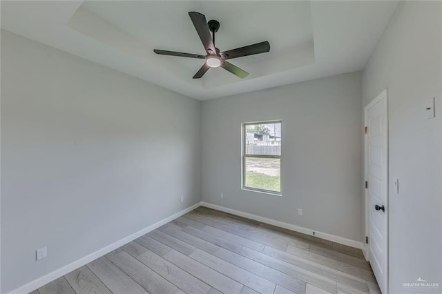 1310 S 9th St, Alamo, TX 78516 - empty room featuring light wood finished floors, a ceiling fan, baseboards, and a tray ceiling